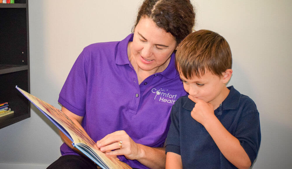 therapist reading a book with a young boy