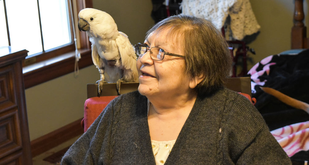 smiling older woman with cockatoo